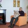 Ein Bewohner genießt seine Lesestunde im Kaminzimmer 