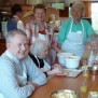 Ehrenamtliche Helfer und Bewohner beim Apfelkuchen backen